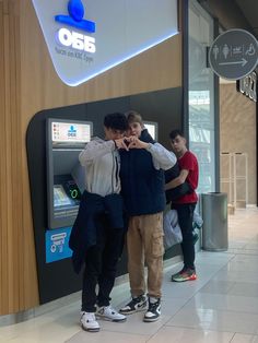 three men standing in front of an atm machine