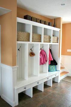 a room with some white shelves and baskets on them