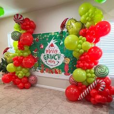 the balloon arch is decorated with candy canes and green, red, and white balloons