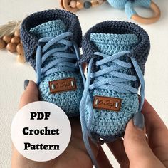 someone is holding up their crocheted baby booties with the tag on it