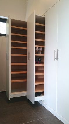 an empty room with white cabinets and brown tile flooring