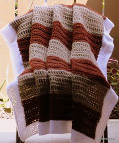 a blanket sitting on top of a chair next to a fence