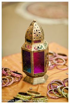 a colorful lantern sitting on top of a wooden table next to other items and decorations