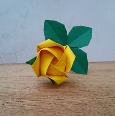 an origami rose sitting on top of a wooden table