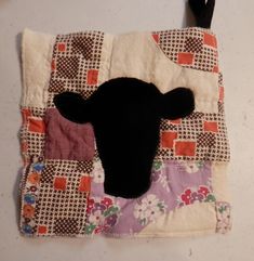 a black sheep head on a patchwork piece of cloth