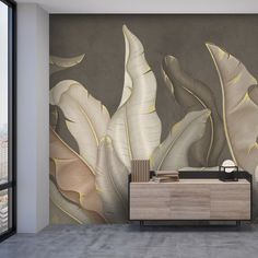 a room with a large wall mural that has leaves painted on it and a sideboard in the corner