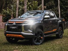 a grey and orange truck parked in the grass