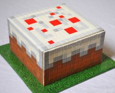 a cake that is made to look like a minecraft house on top of grass