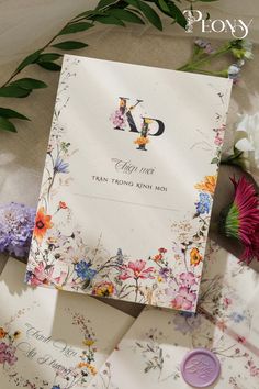 the wedding stationery is surrounded by flowers