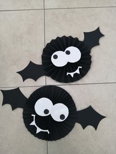 two paper plates with bats on them sitting on a tile floor next to each other