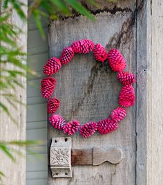 a wooden door with a pink wreath on it