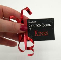 a woman's hand holding a coupon book with red ribbon around it and the words kinks on it