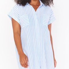 *Medium Weight Drapey Fabric - 60% Polyester, 40% Cotton *Front Button Down Closure *Two Front Pockets *33 3/4" From Shoulder To Hem *Imported Blue V-neck Shirt Dress For Vacation, Light Blue Button-up Beach Dresses, Blue V-neck Shirt Dress For Day Out, Striped V-neck Shirt Dress For Beach, Vacation Striped Button-up Shirt Dress, Striped Short-sleeved Shirt Dress For Vacation, Striped Short Sleeve Shirt Dress For Vacation, Striped Button-up Shirt Dress For Vacation, Blue Collared Relaxed Fit Shirt Dress