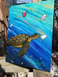 a painting of a sea turtle with plastic cups on it's back