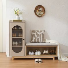 there is a shoe cabinet with shoes on the bottom shelf and a pillow next to it