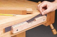 a person is working on a wooden table with a large knife and some woodworking tools