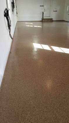 an empty room with white walls and brown flooring is seen in this image from the inside