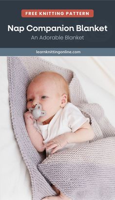 a baby laying on top of a blanket with a pacifier in its mouth