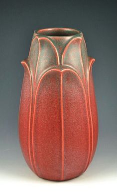 a red vase sitting on top of a table