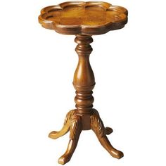 a wooden table with an ornate design on the top and legs, sitting against a white background