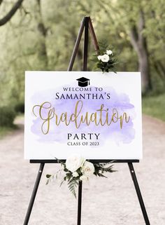 a welcome sign for a graduation party with flowers and greenery on the bottom of it