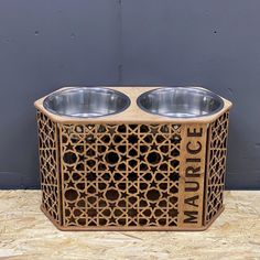 two stainless steel bowls are sitting on top of a wooden box that says marcce