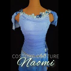 a woman's blue dress with beading and sequins on the shoulders