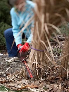 a woman kneeling down next to a fire hydrant with a hose in her hand