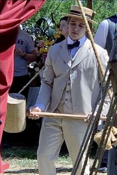 a man in a suit and bow tie holding a stick