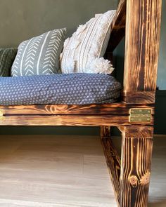 a wooden bench with pillows on top of it