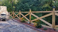 a wooden fence next to a stone patio