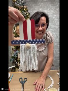 an older woman is holding up a patriotic ornament