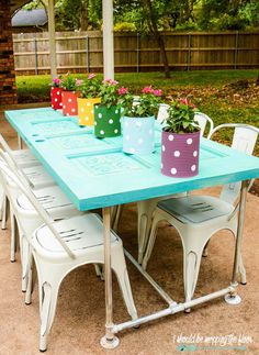 an outdoor table with potted plants on it