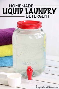 a mason jar filled with liquid sitting on top of a wooden table next to towels