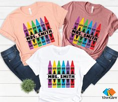 "Customized Teacher Shirt. Perfect for back to school, this personalized crayon teacher shirt makes a great teacher gift. Ideal for kindergarten teaching with your name on it!" Hi! Welcome to our store. It's good to see you here. Our aim is to offer you first-class clothing in your most beautiful moments with our graphic t-shirts that we designed or designed with your ideas. I am sure you will like our designs for your family, friends and you. IMPORTANT MATTERS FOR ORDERING: 1-) Please check and Kindergarten Shirts For Teachers, Class Outfit, Kindergarten Teaching, Good To See You, Great Teacher Gifts, Teaching Kindergarten, School Shirts