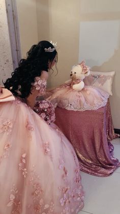 a woman in a pink dress sitting next to a teddy bear