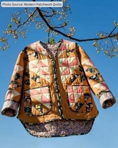 an orange jacket hanging from a tree branch