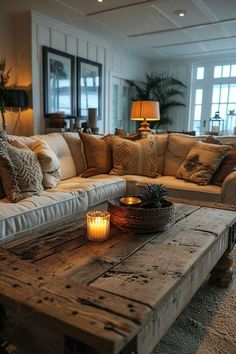 a living room filled with lots of furniture and candles on top of a wooden table