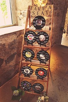 a wooden shelf with several different types of cheese on it in front of a window