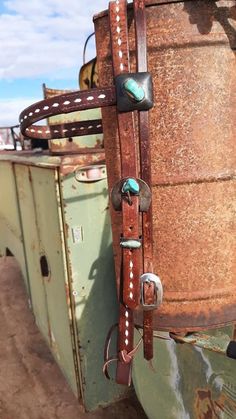 an old rusted metal barrel with leather straps