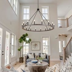 a living room filled with furniture and a large chandelier hanging from the ceiling