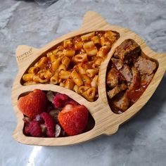 pasta, meat and fruit are arranged in the shape of a fish