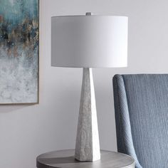 a lamp sitting on top of a table next to a blue chair