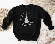 Tyler Childers Sweatshirt, Tyler Childers Sweater, Tyler Childers Crewneck, Tyler Childers Merch, Tyler Childers Unisex Sweatshirt About Ideal for any situation, a unisex heavy blend crewneck sweatshirt is pure comfort. These garments are made from polyester and cotton. This combination helps designs come out looking fresh and beautiful. The collar is ribbed knit, so it retains its shape even after washing. There are no itchy side seams on these sweaters. Without side seams Knit in one piece usi Black Cotton Sweatshirt With Band Logo, Band Logo Cotton Sweatshirt For Fans, Cotton Band Merch Short Sleeve Sweatshirt, Cotton Short Sleeve Sweatshirt Band Merch, Band Logo Cotton Tops For Fall, Cotton Band Logo Tops For Fall, Tyler Childers Shirt, Tyler Childers, Cute Sweats