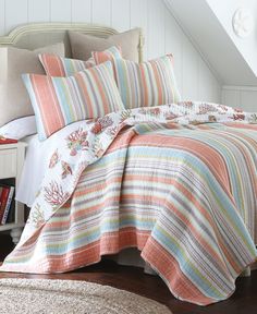 the bed is covered with colorful striped comforters