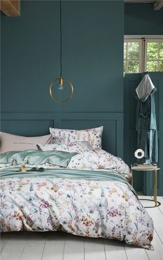 a bedroom with teal walls and floral bedding