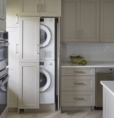 a washer and dryer sitting in a kitchen next to each other on top of cabinets