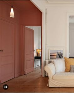 a living room filled with furniture and walls painted in different shades of pink, yellow and white