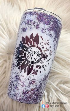 a purple and white glittered tumbler sitting on top of a fur covered floor