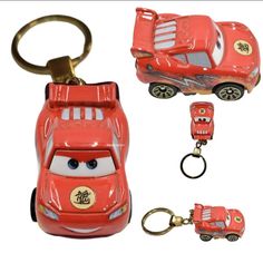 a red toy car keychain with two cars attached to it's sides